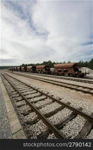 A shot of a railroad station with parked wagons in line.