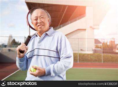 A shot of a senior asian man playing tennis