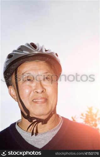 A shot of a senior asian man wearing a bike helmet