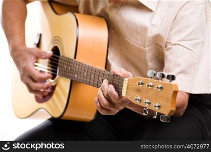 A shot of a senior man playing guitar