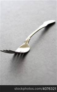 A shot of a silver fork on a black table