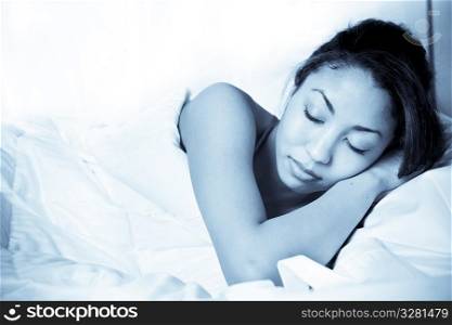A shot of a sleeping black woman on her bed