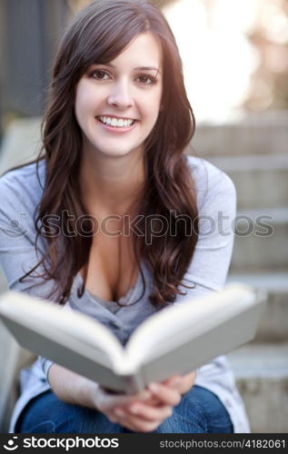 A shot of a smiling college student reading a book