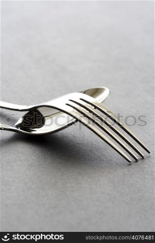 A shot of a spoon and a fork on black