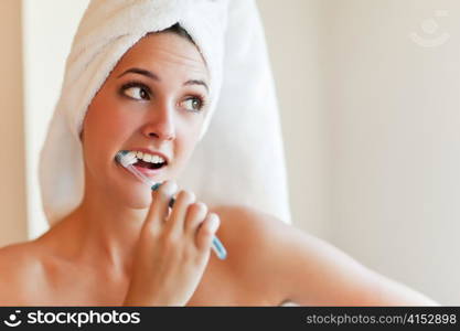 A shot of a young beautiful woman brushing her teeth