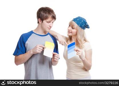 A shot of a young couple choosing paint colors