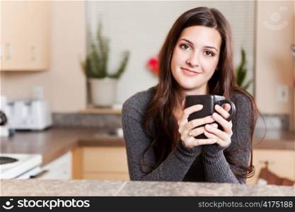 A shot of a young woman holding a cup of coffee