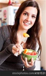 A shot of a young woman holding a fruit bowl