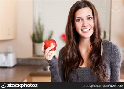 A shot of a young woman holding an apple