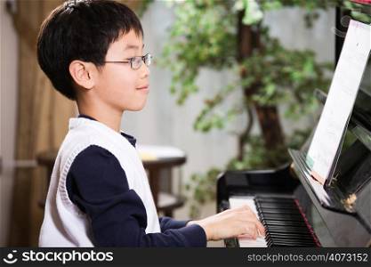 A shot of an asian boy playing piano