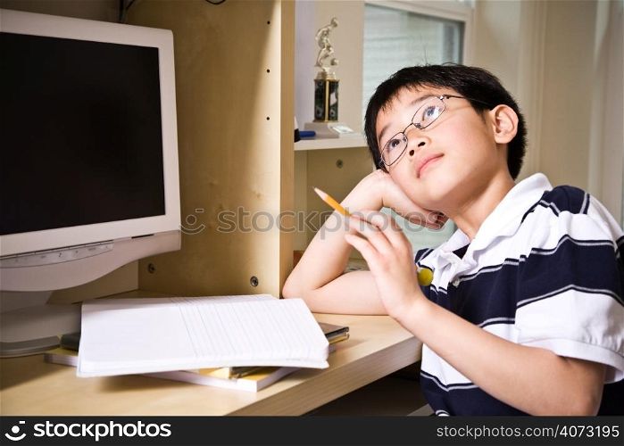 A shot of an asian kid studying at home