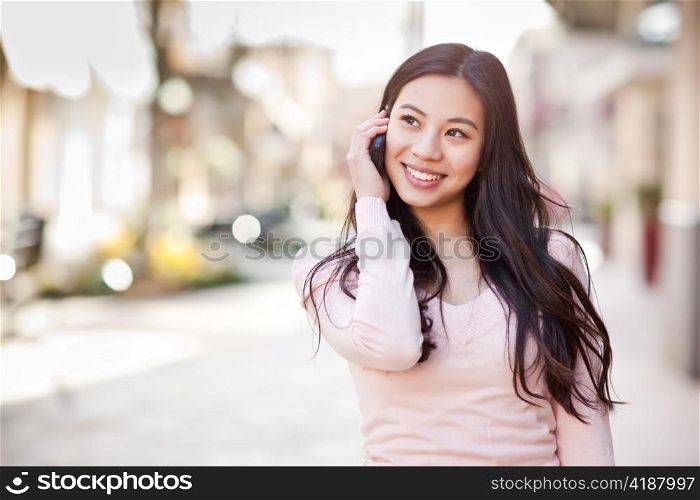 A shot of an asian woman talking on the phone