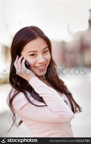 A shot of an asian woman talking on the phone