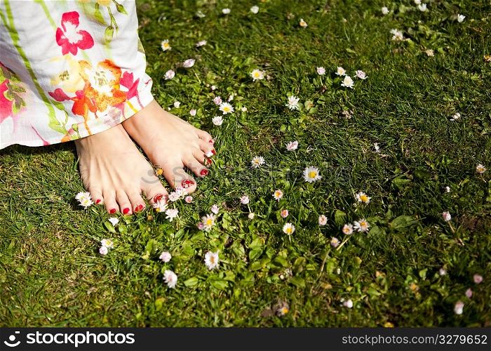 A shot of feet of a woman standing on the grass