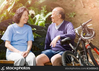 A shot of senior asian couple sitting on a bench at a park
