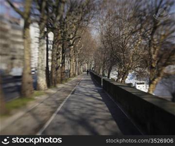 A sidewalk alongside the Seine River in Paris extends into the distance. Note that this image shows the lens blur effect that comes with a Lensbaby.