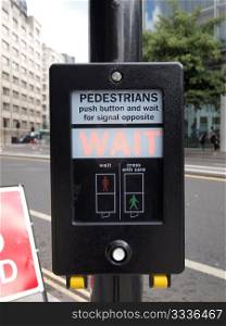 A sign. A pedestrian crossing sign - press button and wait for signal opposite