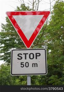 A sign. Detail of a traffic sign - Give way and Stop 50 m