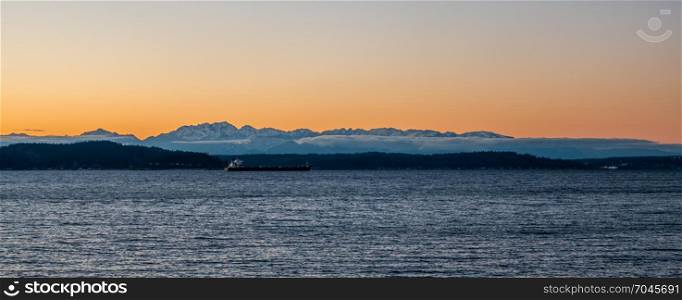 A silhouette of the Olympic Mountains at sunset. Panoramic shot.