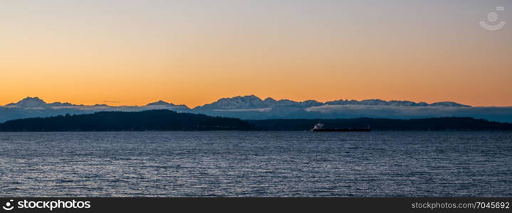 A silhouette of the Olympic Mountains at sunset. Panoramic shot.