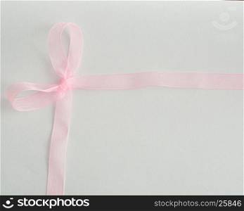 A silky ribbon that is tied into a bow isolated on a white background