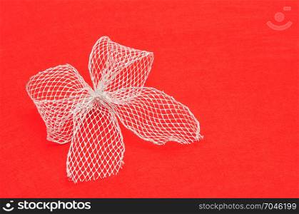 A silver bow isolated on a red background
