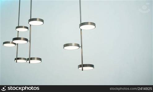 A silver metal lamp in cylinder shape hangs on the ceiling.