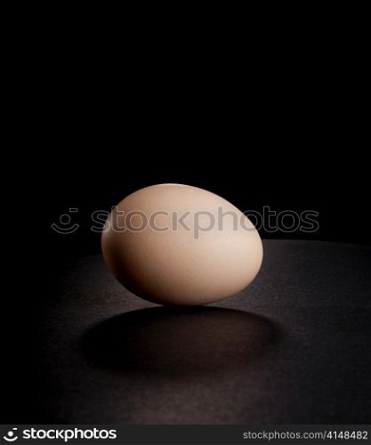 A single egg shot on black with a horizon line