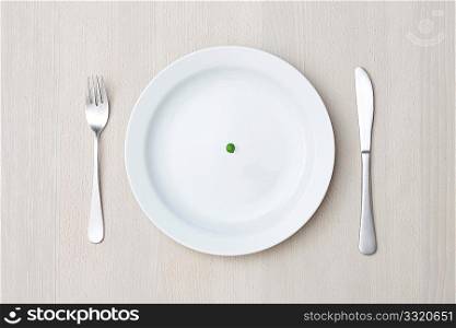 A single pea on a plate