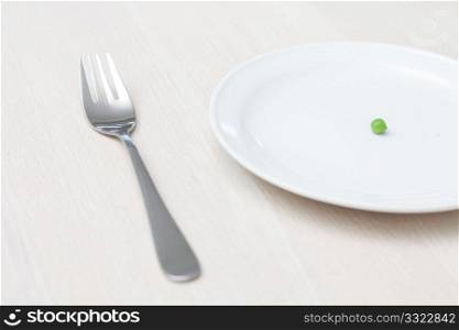 A single pea on a plate