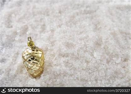 A single pine cone on a snow background with top down angle