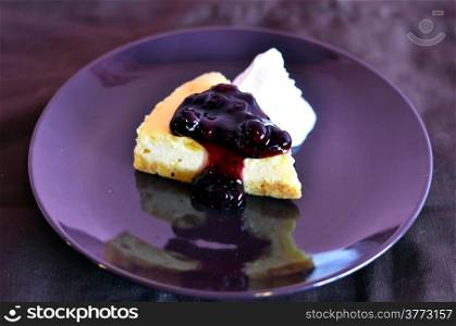 a slice of blueberry cheese cake served with whipped cream