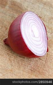 A sliced red onion on a wooden background