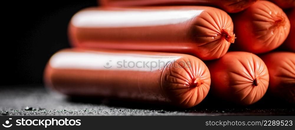 A slide of sausages on the table. On a black background. High quality photo. A slide of sausages on the table.