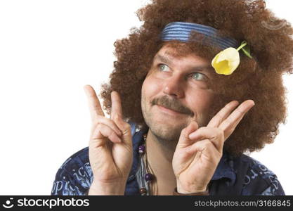 A slightly too old hippie making the peace sign with a tulip in his hair