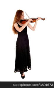 A slim young woman in a long black dress standing for white backgroundplaying the violin.