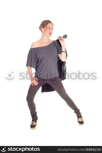 A slim young woman in jeans with her jacket in her hand isready for a walk, isolated for white background