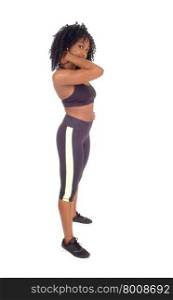 A slime African American woman in black exercise clothing standing inprofile, showing her great figure, isolated for white background.