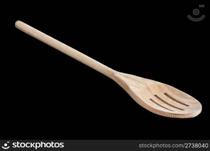 A slotted wooden kitchen spoon isolated on a black background.