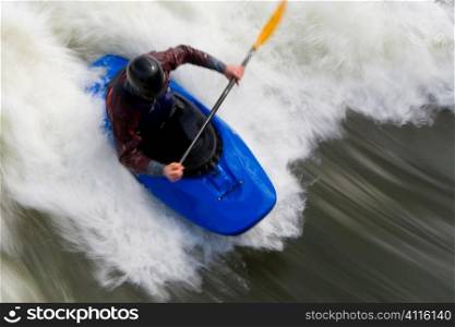 A slow shutterspeed shot of a kayaker in very rough whitewater.