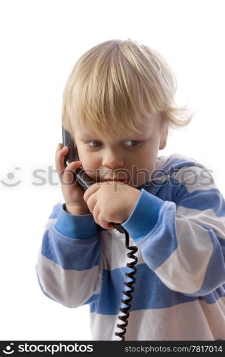 A small, 3 year old boy whispering on the telephone