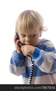 A small, 3 year old boy whispering on the telephone