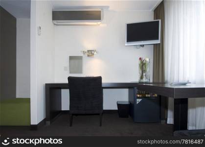 A small, but luxurious and modern styled hotel room with various appliances and features