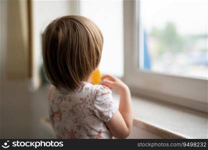 a small child looks out the window from behind