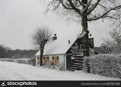 A small cottage on an abandonned snowy road