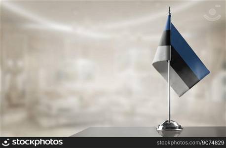 A small Estonia flag on an abstract blurry background.. A small Estonia flag on an abstract blurry background