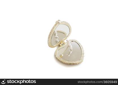 A small figurine standing on an open heart shape pendant over white background