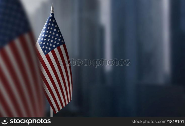 A small flag of United States on the background of a blurred background.. A small flag of United States on the background of a blurred background