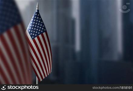 A small flag of United States on the background of a blurred background.. A small flag of United States on the background of a blurred background