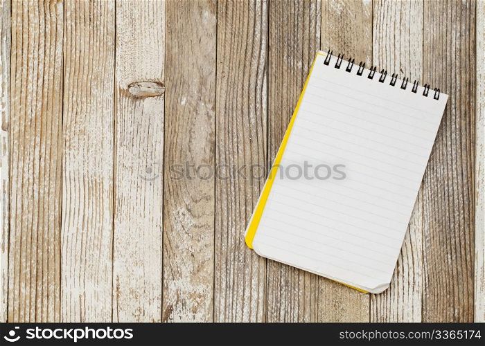 a small lined notebook on a rustic grunge wooden table